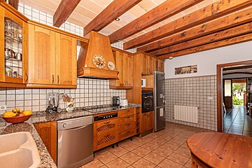 A kitchen with wooden cabinets and a clock on the ceiling