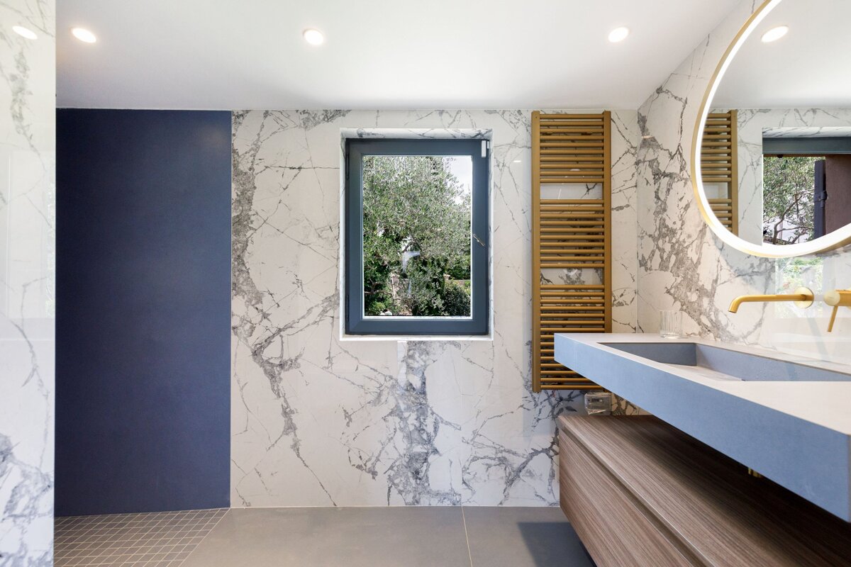 A bathroom with marble walls and a window