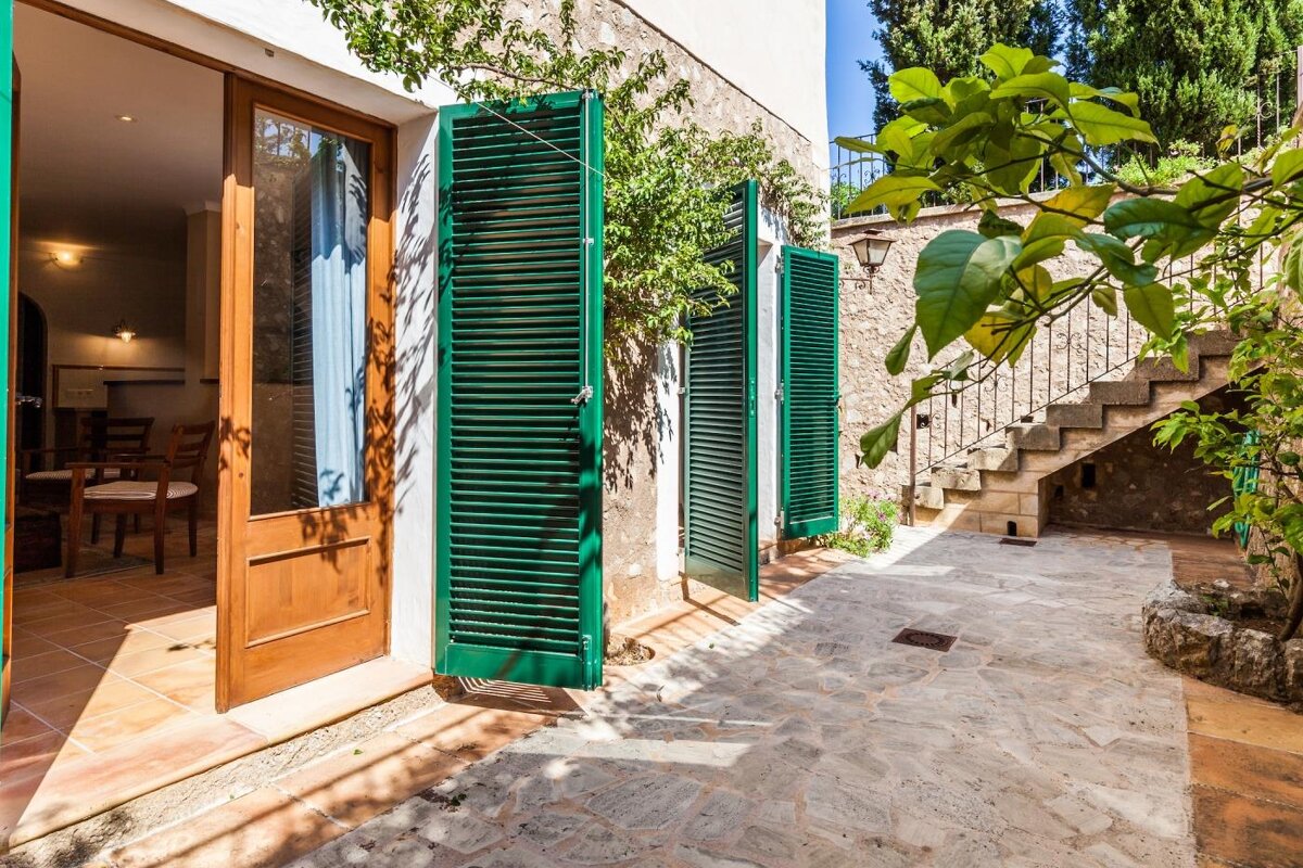 A house with green shutters on the windows and doors
