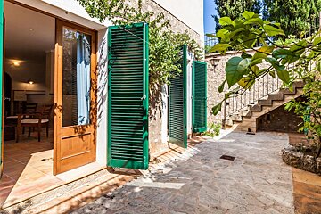 A house with green shutters on the windows and doors