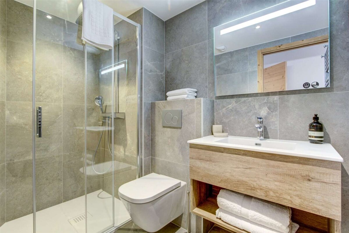 A bathroom with a toilet a sink and a mirror