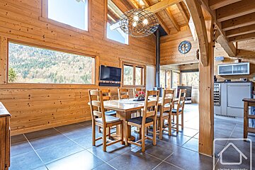 A wooden dining room with a table and chairs