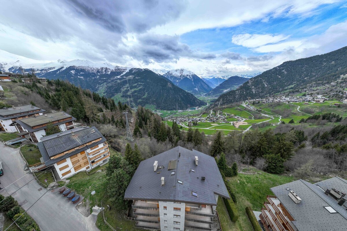An aerial view of a valley with mountains in the background