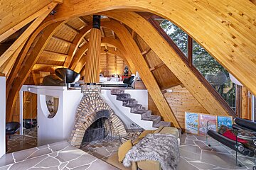 A wooden house with a fireplace and stairs
