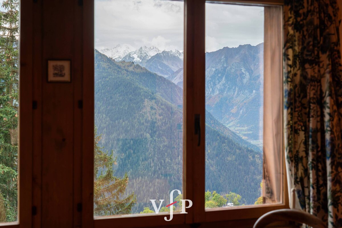 A window with a view of the mountains and the letter v on it