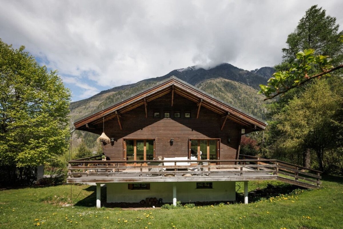 A wooden house with mountains in the background