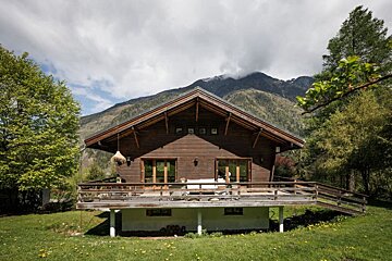 A wooden house with mountains in the background