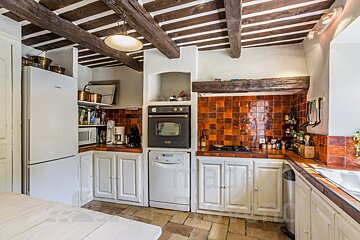 A kitchen with white cabinets and a black oven