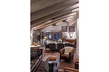 A living room with a dining room in the background