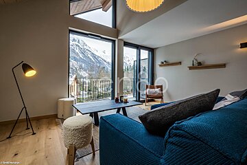 A living room with a blue couch and a view of the mountains