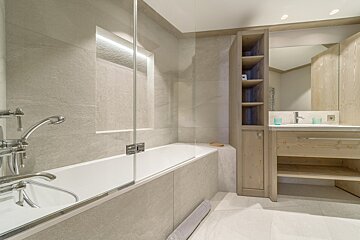 A bathroom with a bathtub a sink and a mirror