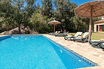 A swimming pool with chairs and umbrellas around it