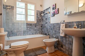 A bathroom with a sink toilet and a bidet