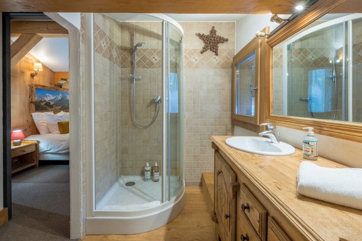A bathroom with a walk in shower and a sink
