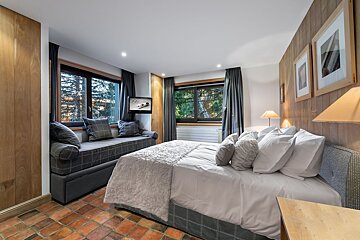 A bedroom with a large bed and a couch