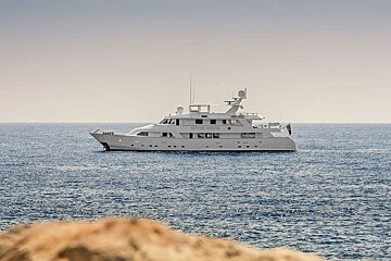 A large white yacht is in the middle of the ocean