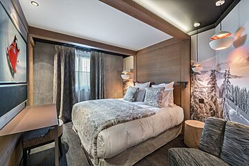 A hotel room with a bed and a television