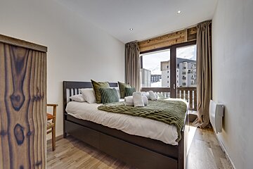 A bedroom with a large bed and a large window