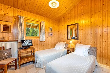 A bedroom with two beds and a tv with the letter b on it
