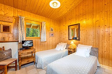 A bedroom with two beds and a tv with the letter b on it
