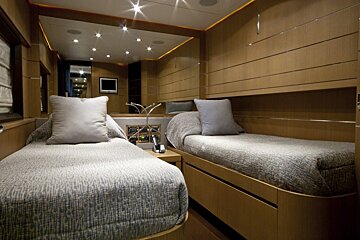 A bedroom with two beds and a mirror