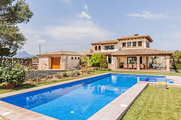 A large house with a large swimming pool in front of it