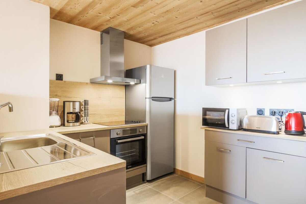 A small kitchen with a stainless steel refrigerator