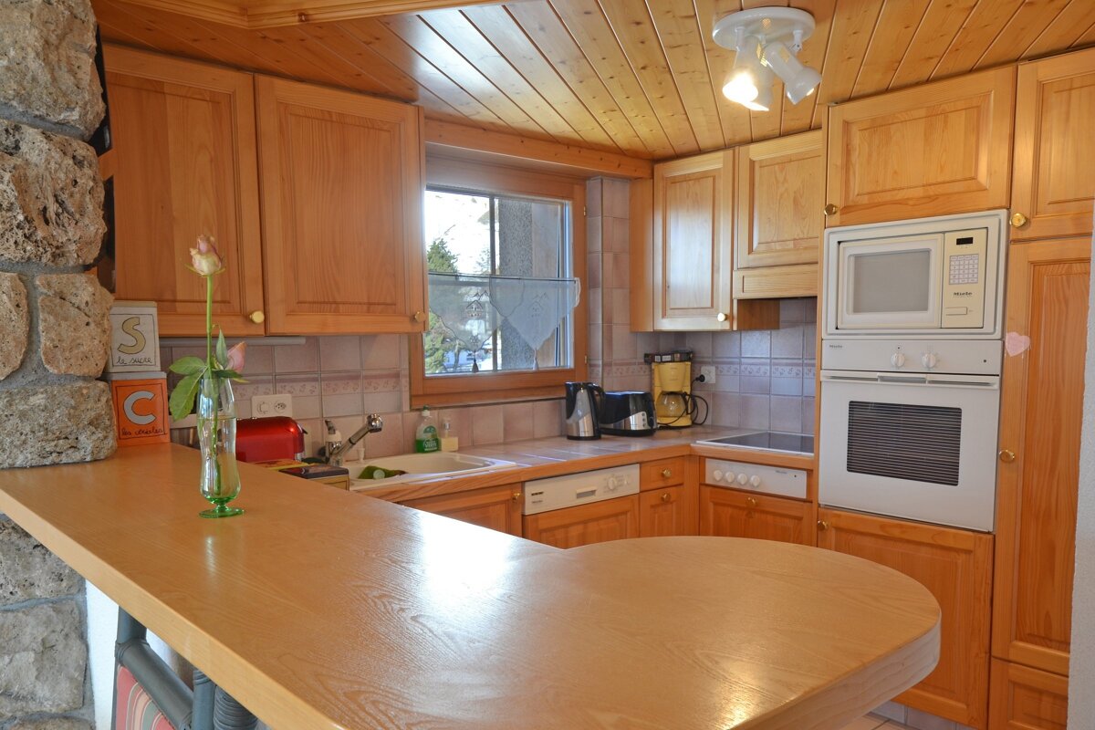 A kitchen with wooden cabinets and a microwave that says siemens on it