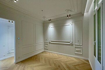 A hallway with a wooden floor and white walls