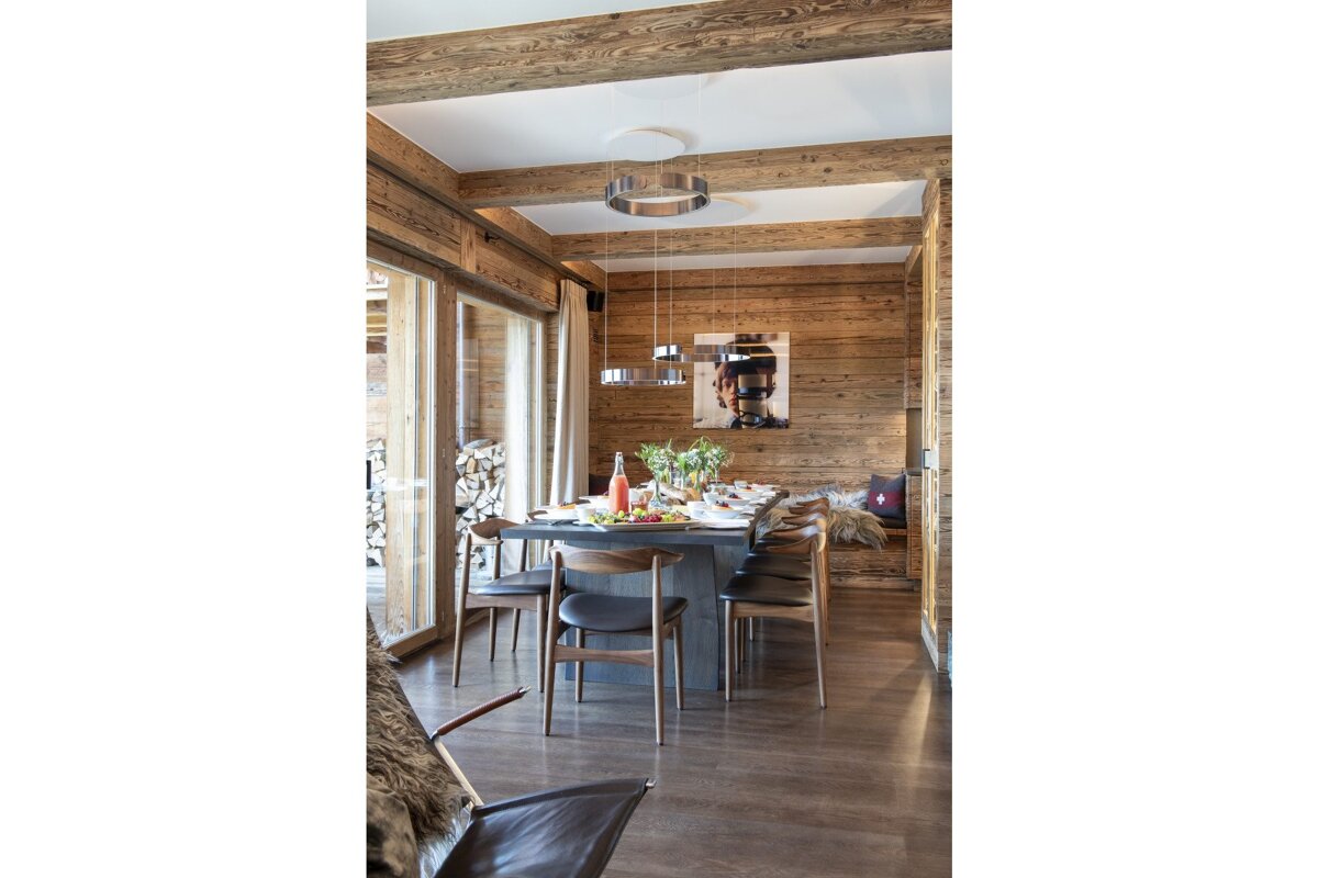 A dining room with a table and chairs and a painting on the wall
