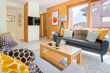 A living room with a couch and a table with a bottle of champagne on it