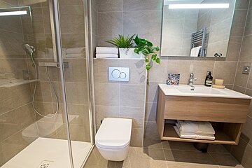 A bathroom with a toilet a sink and a mirror