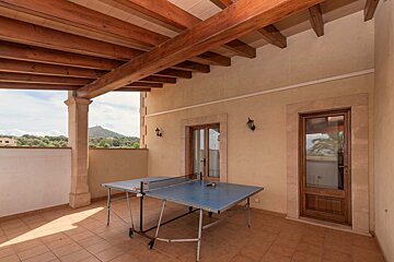 A ping pong table on a balcony with a mountain in the background