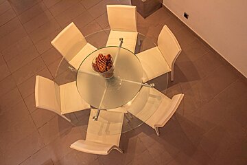 A glass table with a bowl of pine cones on it