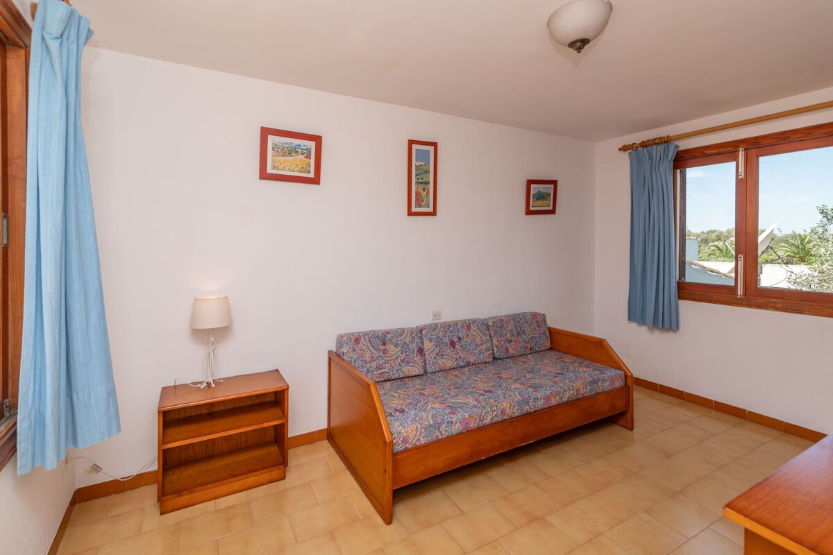 A living room with a couch and two pictures on the wall