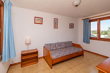 A living room with a couch and two pictures on the wall