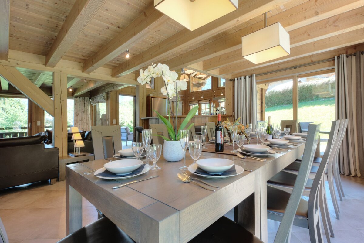 A dining room table with a bottle of wine on it