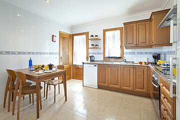 A kitchen with a table and chairs and a dishwasher