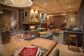 A living room with a fireplace and a dining table