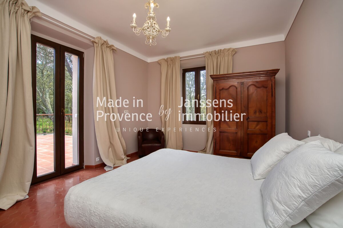 A bedroom with a bed and a wardrobe made in provence by janssens immobilier