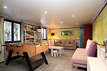 A living room with a foosball table and a couch