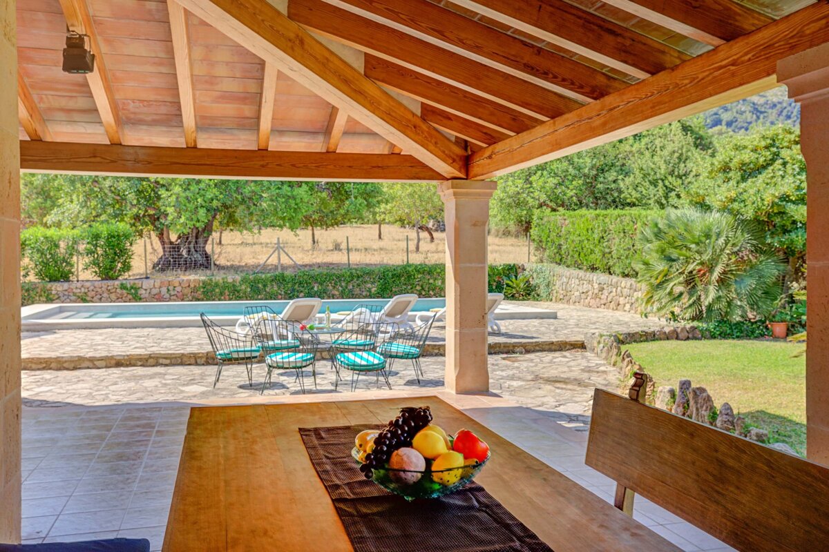A wooden table with a bowl of fruit on it