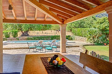 A wooden table with a bowl of fruit on it