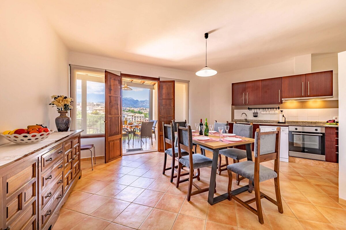 A kitchen with a table and chairs and a balcony