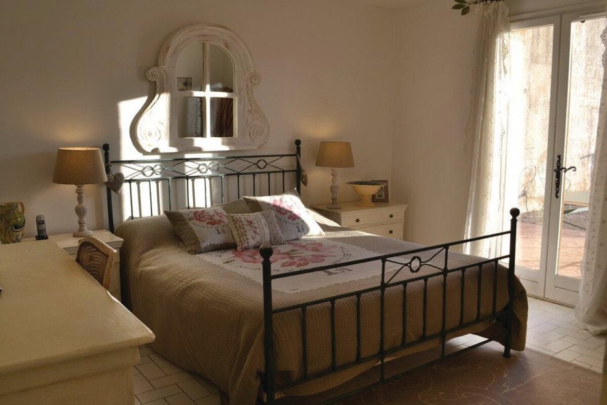 A bedroom with a wrought iron bed and a mirror