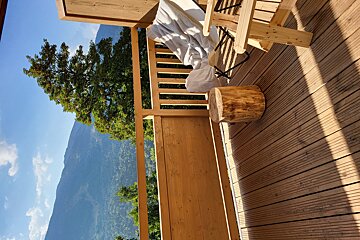 A wooden deck with a chair and a stump on it
