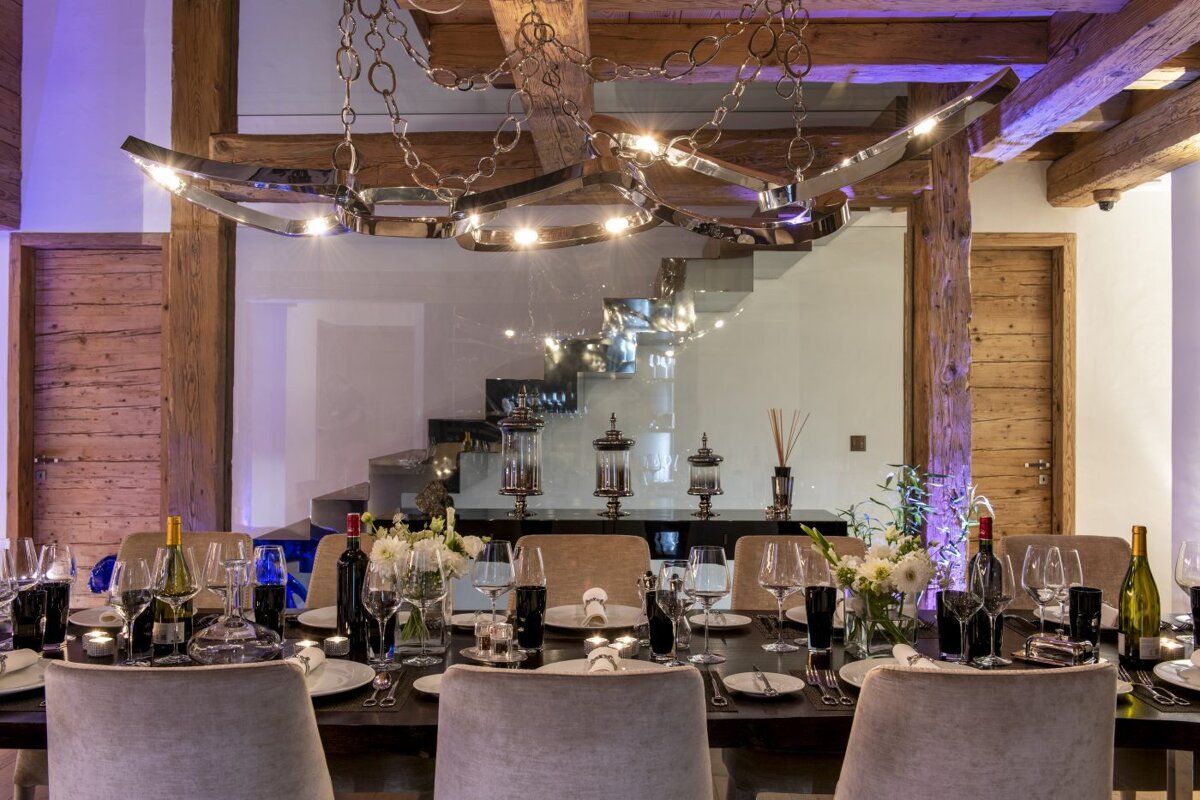A dining room table is set with plates and glasses