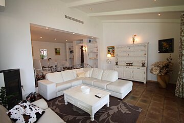 A living room with a white sectional couch and a white coffee table