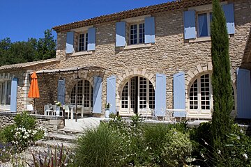 A large stone house with blue shutters on the windows