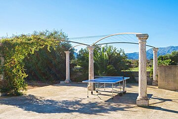 A table and chairs on a patio with trees in the background